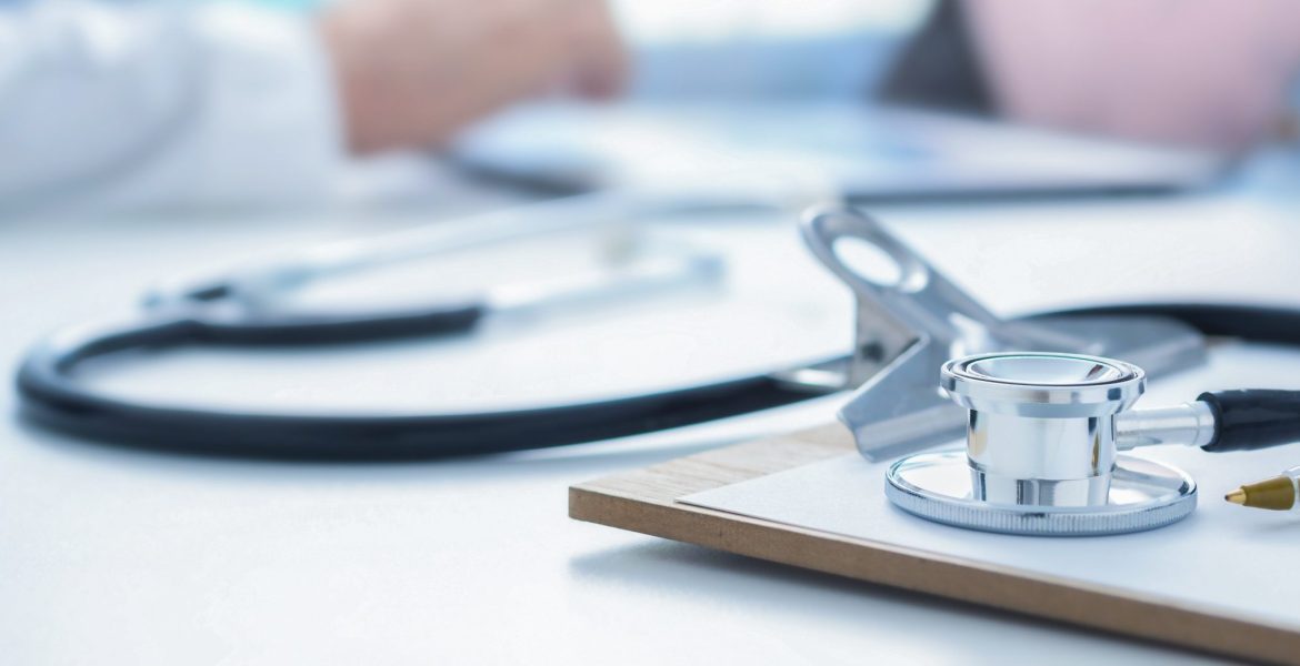 Stethoscope and clip board on doctor workplace close up
