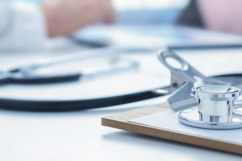 Stethoscope and clip board on doctor workplace close up